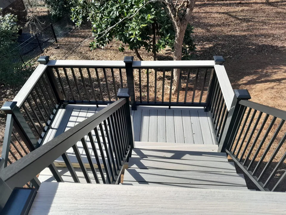 Deck stairs with black railing and light deck boards