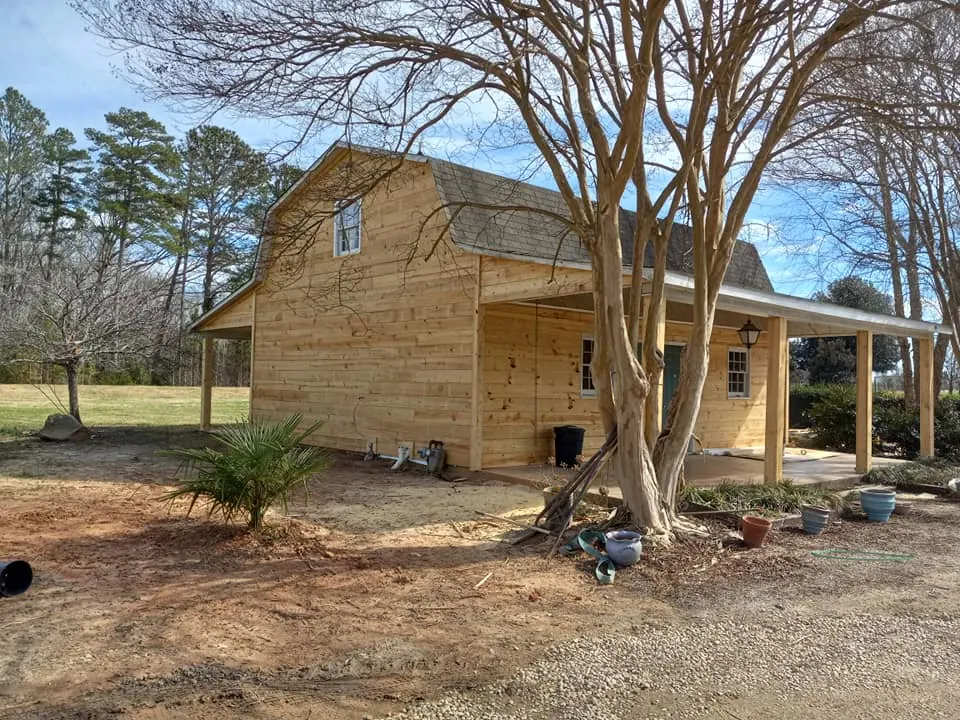 Freestanding wood structure with porch posts and wraparound roofline