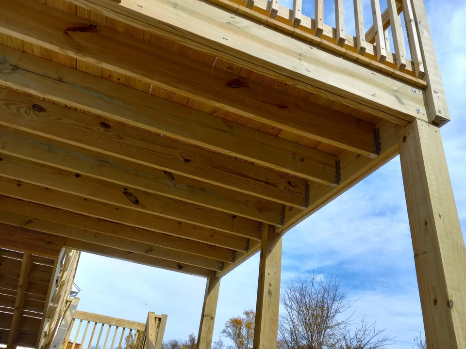 Underside of a wood deck showing framing and posts
