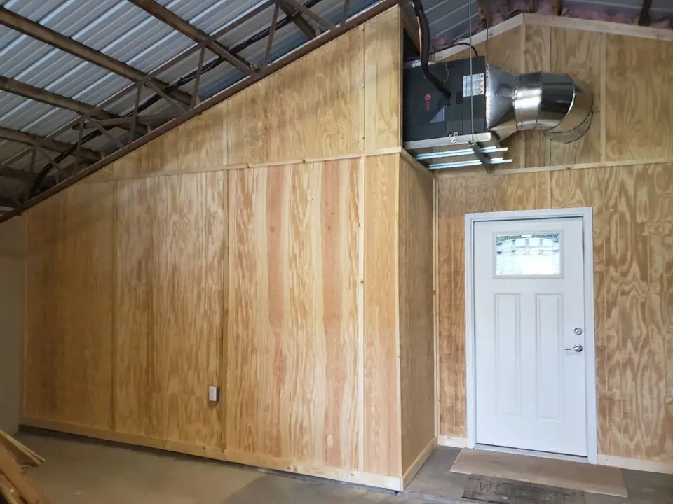 Finished wood wall detail with a white door inside a shop structure