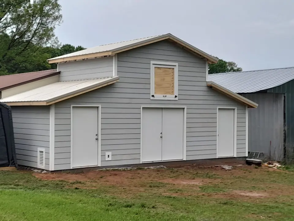 Gray outbuilding exterior with multiple doors
