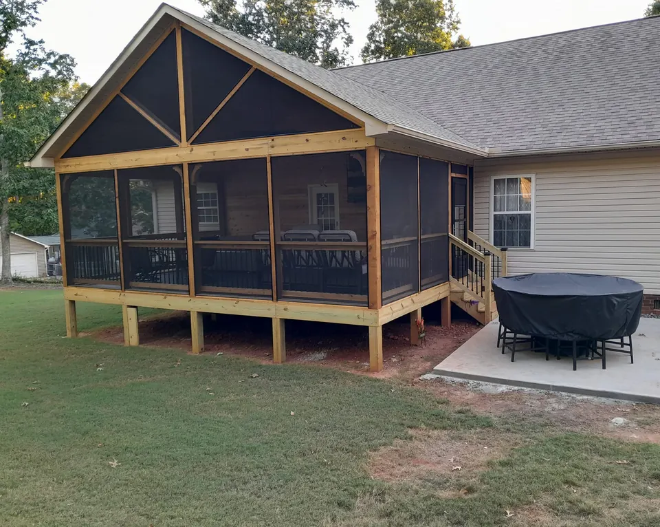 Two-level screened home add-on with wood framing and black screen panels